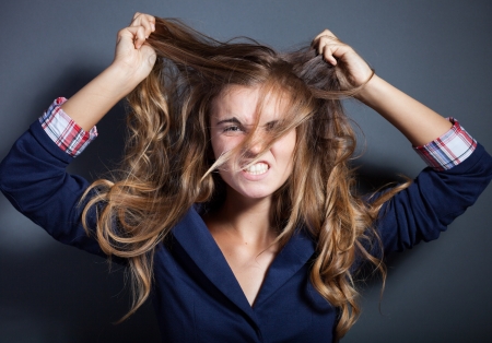Shouting angry girl pulling her hairの写真素材