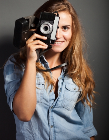 Silly photographer woman taking pictures with old cameraの写真素材