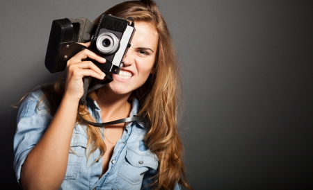 Silly photographer woman taking pictures with old cameraの写真素材