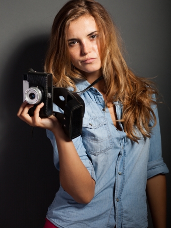 Thinking photographer woman holding old cameraの写真素材