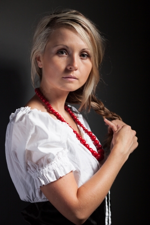 Folk woman in folklore clothes from Europe braiding a plaitの写真素材
