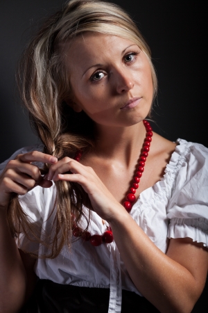 Folk woman in folklore clothes from Europe braiding a plaitの写真素材