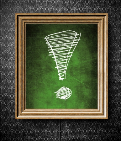 Exclamation mark chalkboard in old wooden frame on vintage wallの写真素材