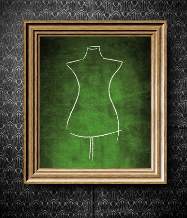 Fashion mannequin sketch chalkboard in old wooden frame on vintage wallの写真素材