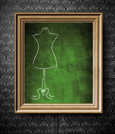 Fashion mannequin sketch with copy-space chalkboard in old wooden frame on vintage wallの写真素材