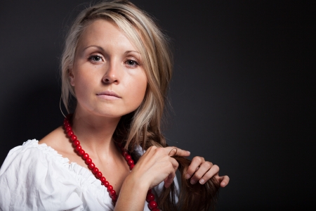 Folk woman in folklore clothes from Europe braiding a plaitの写真素材