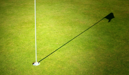 Golf course green grass with cup and flagの写真素材