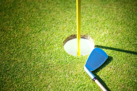 Golf cup with club on greenの写真素材
