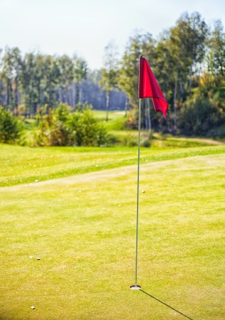 Golf-cup with flag on green, golf course landscapeの写真素材