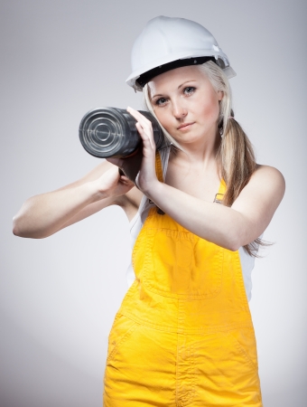 Young builder woman construction worker with blueprints planの写真素材