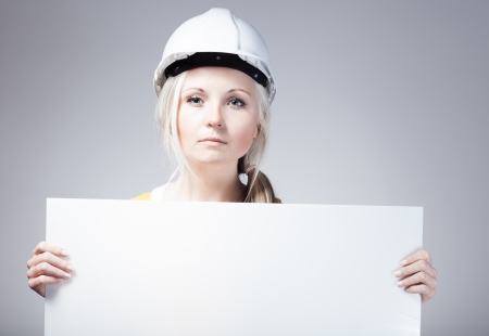 Young builder craftswoman construction worker and empty frameの写真素材