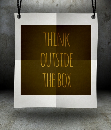 Think outside the box concept on paper poster hanging on a ropeの写真素材