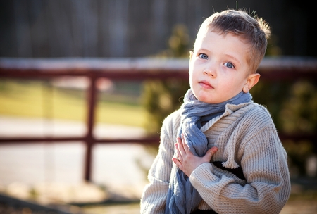 Child portrait of beautiful little boy in sweater and scarfの写真素材