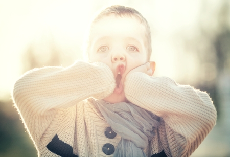 Child portrait of beautiful little boy in sweater and scarfの写真素材
