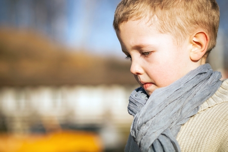 Child portrait of beautiful little boy in sweater and scarfの写真素材