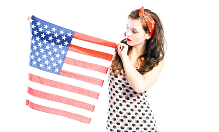 Pin up girl posing with american flag isolated on whiteの写真素材