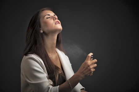 Vintage glamour elegant woman spraying perfumeの写真素材