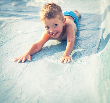 Child on water slide at aquapark during summer holidayの写真素材