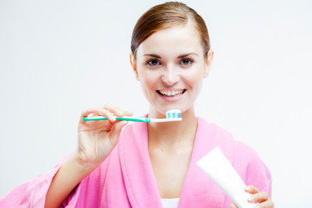 Beautiful woman with toothbrush and tooth paste tube, dental care conceptの写真素材