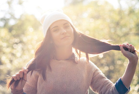 Young woman outdoor portrait in soft sunny daylightの写真素材