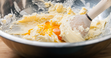 Kneading dough in mixing bowl, close up butter and flourの写真素材