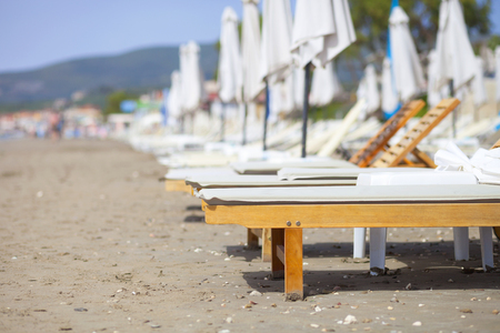 Empty sun loungers on the beach before summerの写真素材
