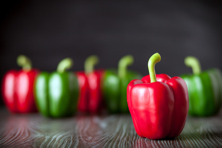 Red and green bell pepper on wooden board dark background, copy spaceの写真素材