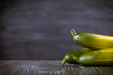 Cucumber on wooden table dark background, copy spaceの写真素材