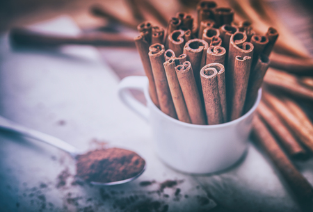 Cinnamon sticks and powder on rustic wooden board, top viewの写真素材