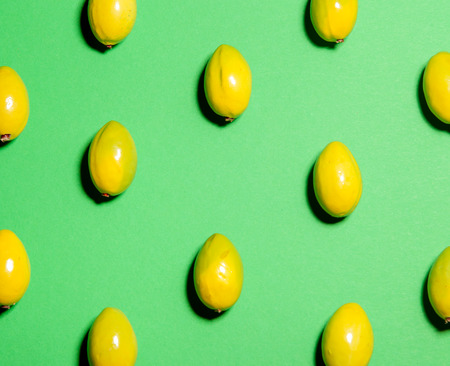 Colorful fruit pattern made of ripe green olives, eating concept