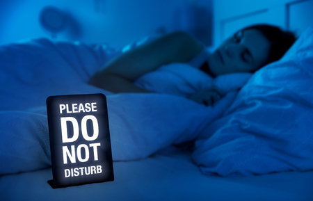 Woman peacefully sleeping in bed at nightの写真素材