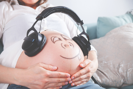 Belly of pregnant woman sitting  at homeの写真素材