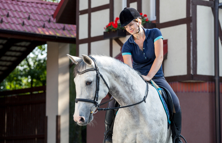 Horse rider woman near stable, horsewoman before trainingの写真素材