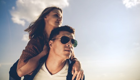 Happy couple having fun outdoor at sunset, love and friendship concept