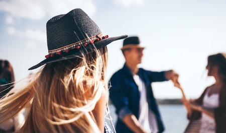 Group of friends dancing and celebrating on beach, boho party outdoor