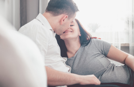 Pregnant couple relaxing at home and enjoying pregnancy timeの写真素材