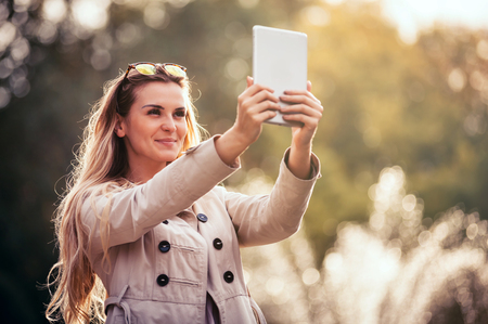 Modern woman in the city using tablet computer, outdoorの写真素材