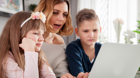 Happy modern family using together pc laptop at home
