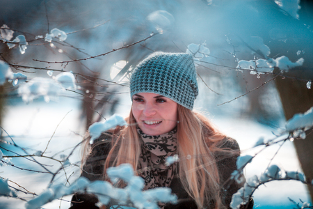 Beautiful young woman smiling in winter forestの写真素材