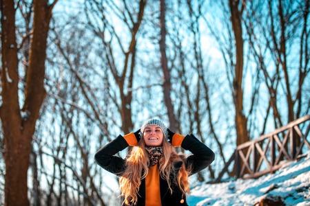 Portrait of smiling beautiful woman in the winter park at sunny dayの写真素材
