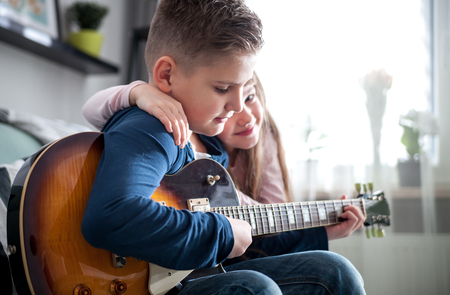 Children playing electric guitar at home, happy familyの写真素材