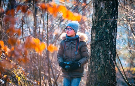 Boy with digital camera walking in the nature, hobbies concept