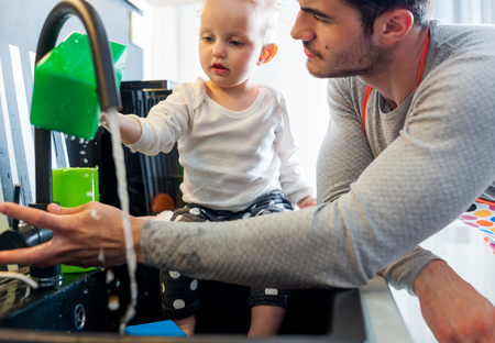 Little child girl in the kitchen having fun with her dad, family lifestyleの写真素材