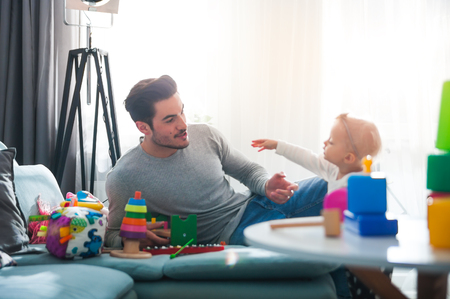 Young father takes care of little daughter at homeの写真素材