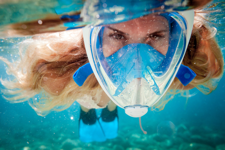 Woman snorkeling with full face mask in the tropical seaの写真素材