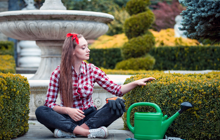 Proud gardener woman touching hedge in her well kept gardenの写真素材