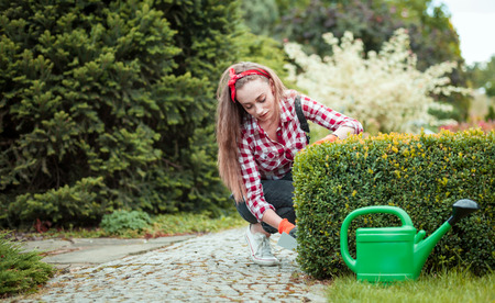 Cheerful gardener woman gardening outdoor