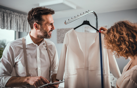 Professional tailors during work talking about project in fashion design studioの写真素材