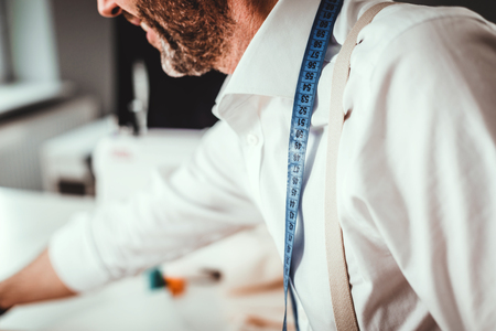 Close up of measuring tape on tailor neck who working in sewing workshopの写真素材