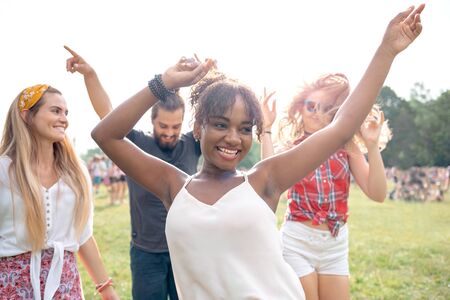 Friends dancing and having fun at summer music festivalの写真素材